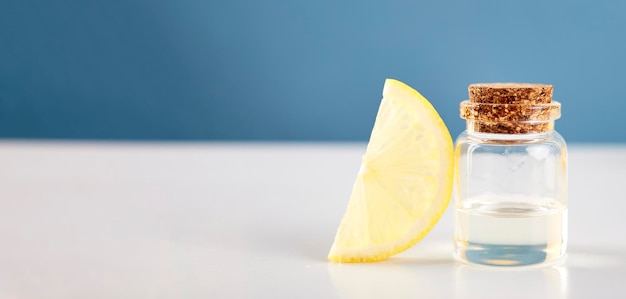 테이블에 레몬 조각이 있는 레몬 에센셜 오일이 든 병 화장품 감귤류 오일 또는 혈청 천연 의학 개념 아로마테라피