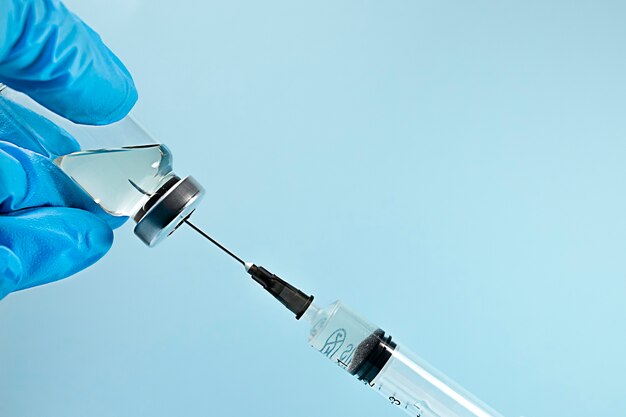 bottle with medicine and syringe on blue background