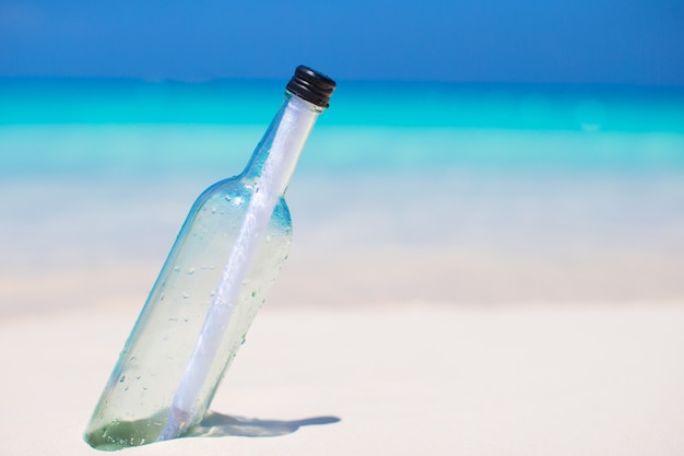 Photo bottle with a message buried in the white sand