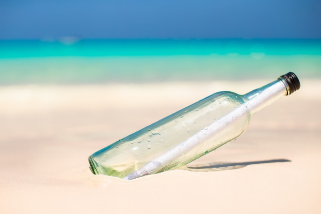 Photo bottle with a message buried in the white sand