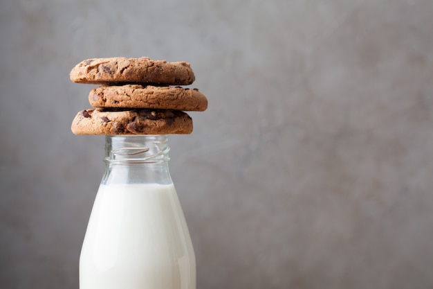 Bottle with milk and chocolate chip cookies.