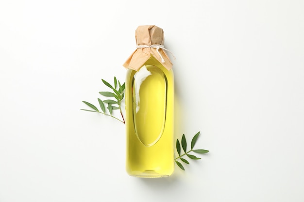 Bottle with olive oil and leaves on white, space for text