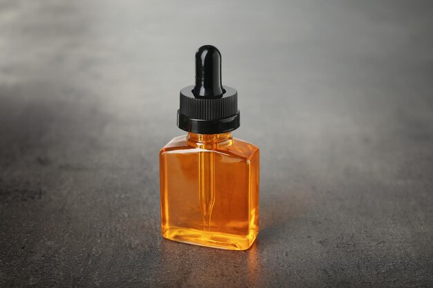 Premium Photo | Bottle with perfume oil on grunge background