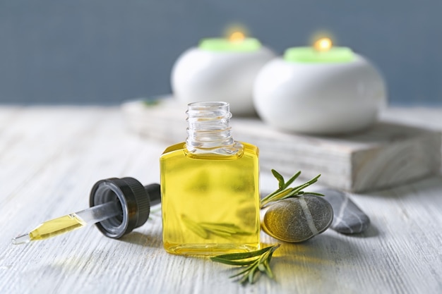 Bottle with rosemary oil on wooden table