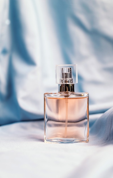 A bottle of women's fragrant perfume on a silk textured fabric