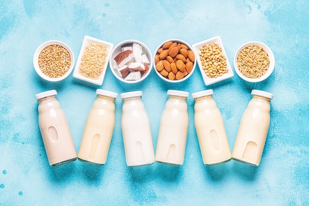 Photo a bottles of alternative  milk and ingredients, top view.