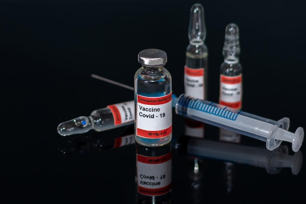 Bottles and ampoules with coronavirus vaccine Syringe and medical ampoules for injection