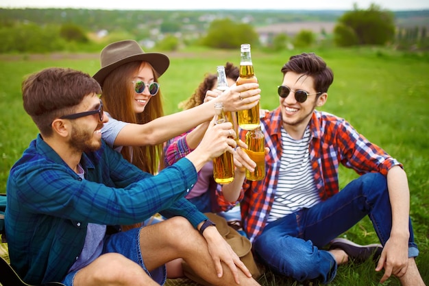 Бутылки пива Группа друзей наслаждается вечеринкой люди пьют пиво и смеются