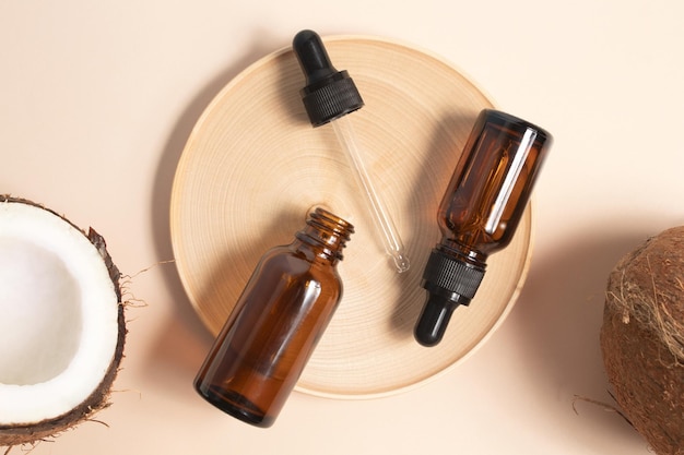 Bottles of coconut oil and fresh coconuts on beige background Coconut natural cosmetics