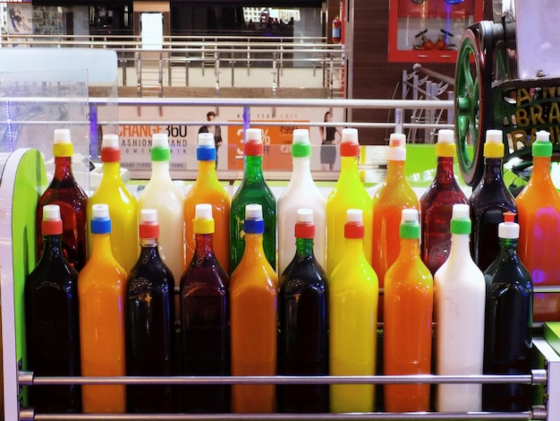 Photo bottles of colorful syrups at market