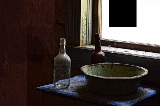 Bottles and container on table in abandoned room