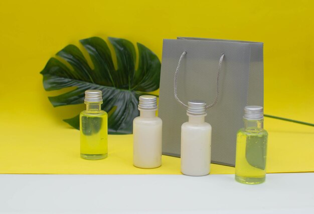 Bottles for cosmetics, natural medicine, essential oils or other liquids. Face / body care concept: bottles of creams/lotions/serums. Gift set for women. Yellow background.