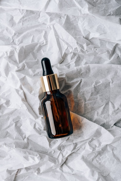 Bottles of cosmetics on white crumpled paper