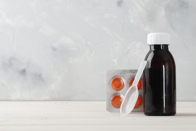 Photo bottles of cough syrup and  blisters with color cough drops  blue background