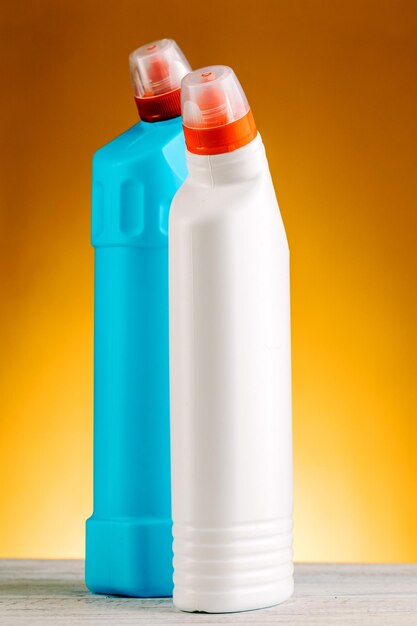 Bottles of detergent and cleaning products on a yellow background