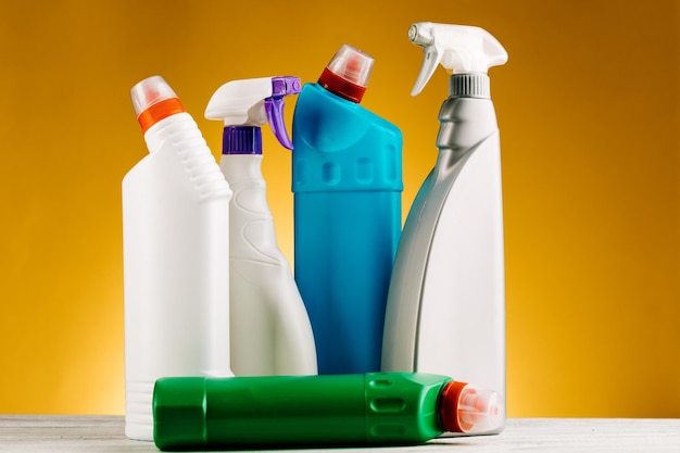 Bottles of detergent and cleaning products on a yellow background.