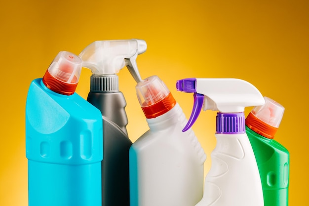 Bottles of detergent and cleaning products on a yellow background