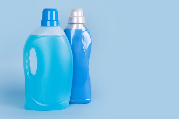 Bottles of detergent and fabric softener on blue background