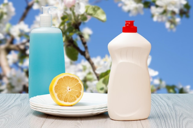 Bottles of dishwashing liquid plates and lemon