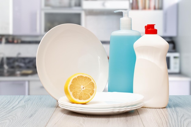 Bottles of dishwashing liquid plates and lemon