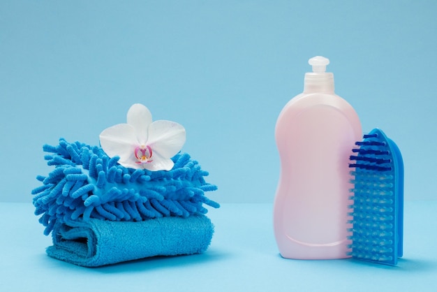 Bottles of dishwashing liquid rags and a brush on the blue background Washing and cleaning set