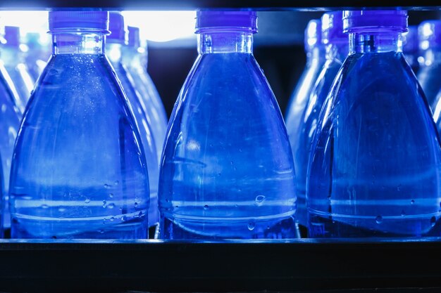 Photo bottles of drinking water in the water production plant