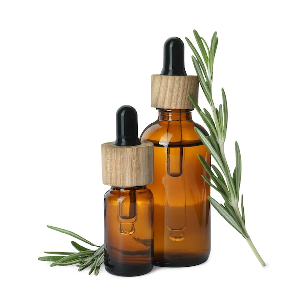 Bottles of essential oil and fresh rosemary isolated on white