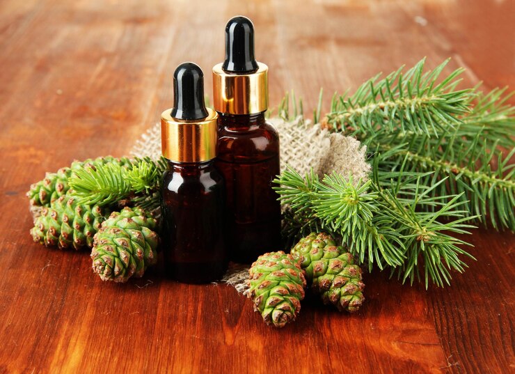 Photo bottles of fir tree oil and green cones on wooden background