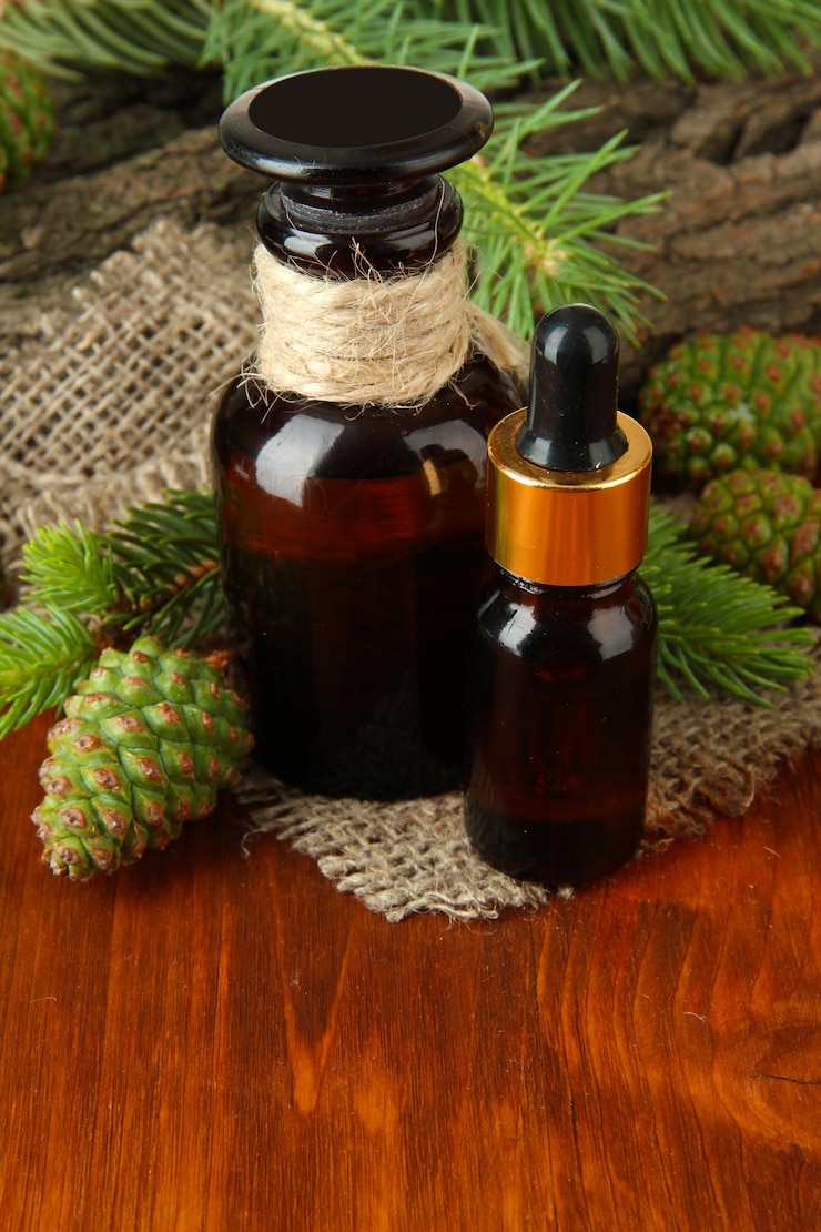 Photo bottles of fir tree oil and green cones on wooden table