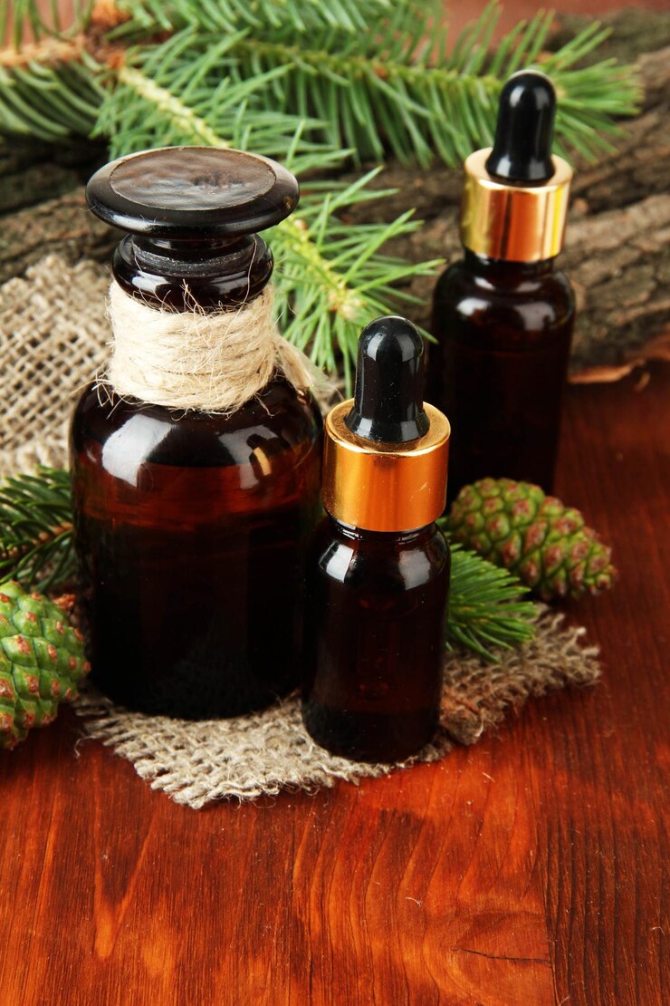 Photo bottles of fir tree oil and green cones on wooden table