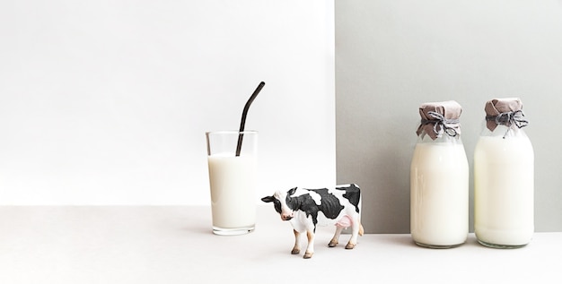 Bottles of fresh milk figurine of a cow and  glass of milk