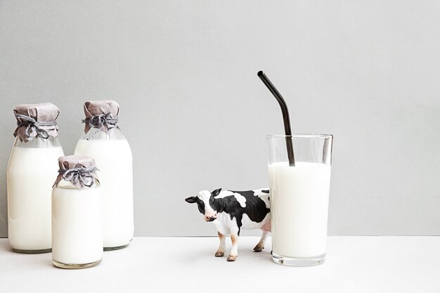 Bottles of fresh milk figurine of cow and glass of milk