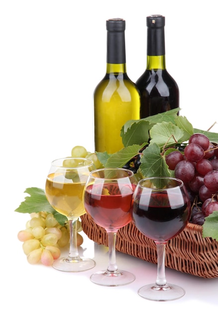bottles and glasses of wine and grapes in basket isolated on white