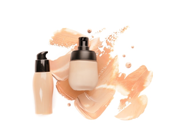 Bottles of makeup foundation and samples on white background