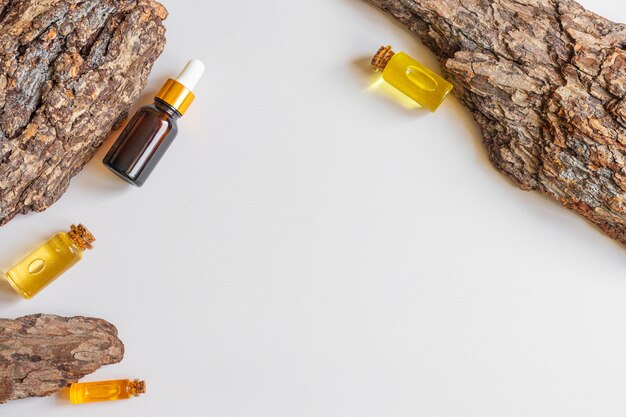 Bottles of natural essential oil and tree bark