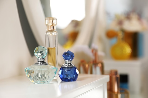 Bottles of perfumes on dressing table in stylish room interior
