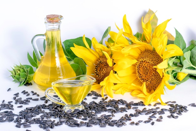 Bottles of sunflower oil and sunflower flowers with seeds on a white background