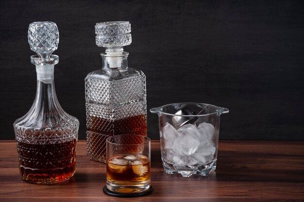 bottles of whiskey, and glass with ice cubes