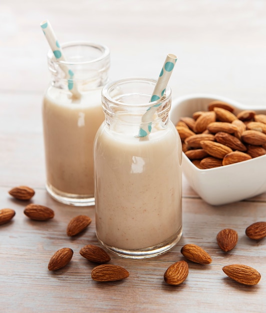 Bottles with almond milk and almonds on the table