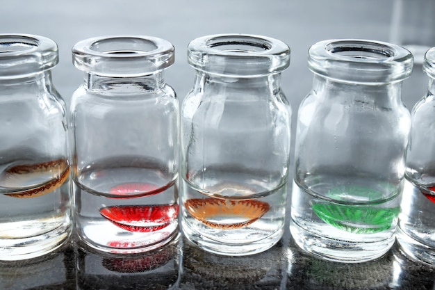 Photo bottles with contact lenses on gray table