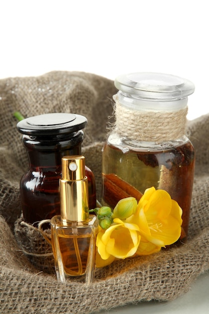 Bottles with ingredients for the perfume on burlap isolated on white