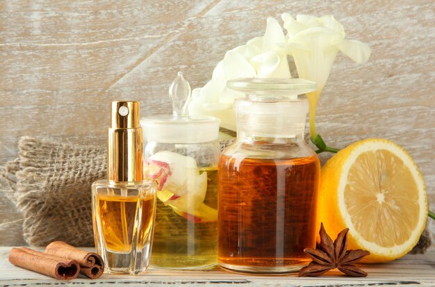 Bottles with ingredients for the perfume on wooden background