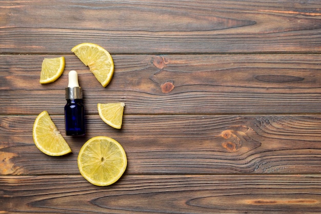 Bottles with lemon fruit essential oil on wooden background alternative medicine top view with copy space