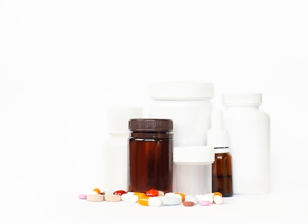 бутылки с лекарствами и таблетками стоят на белом фоне