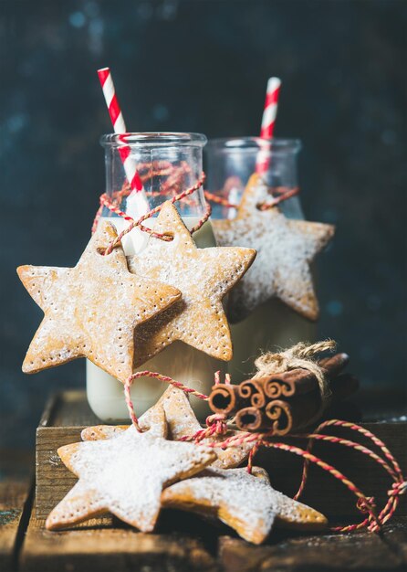 Bottles with milk and Christmas festive gingerbread star shaped cookies