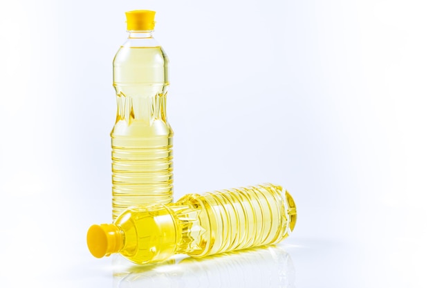 Bottles with natural sunflower oil on a white background Vegetable oilPlastic bottle of vegetable