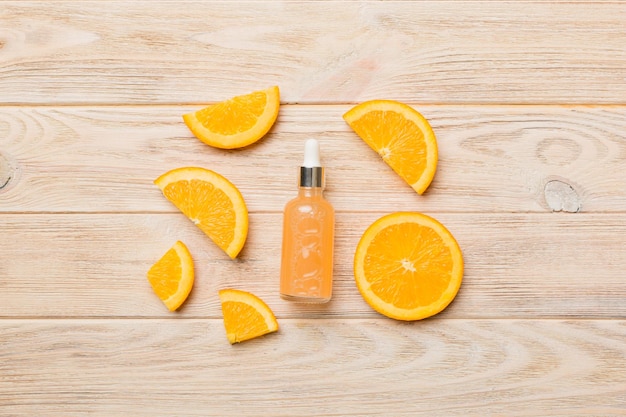 Bottles with orange fruit essential oil on wooden background alternative medicine top view with copy space