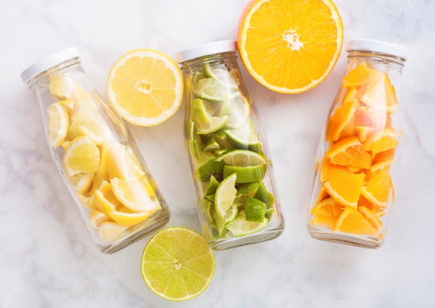 Bottles with oranges with limes and lemons slices