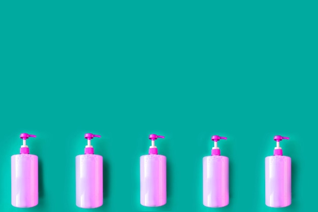 Photo bottles with pink dishwashing liquid on blue background minimal concept copy space for the text