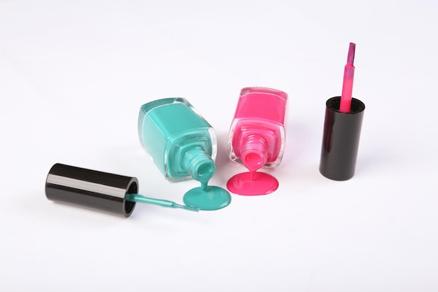 bottles with spilled nail polish isolated on white background